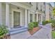 Covered townhouse entryway with classic pillars, trimmed hedges, and a gray entryway step at 312 Grand Bay Ln, Celebration, FL 34747