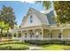 Charming home exterior featuring a covered front porch, manicured lawn, and lush landscaping at 312 Grand Bay Ln, Celebration, FL 34747