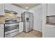 Contemporary kitchen with stainless steel appliances, white cabinetry, and durable tile flooring, offering modern convenience at 312 Grand Bay Ln, Celebration, FL 34747