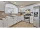 Modern kitchen with white cabinets, stainless steel appliances, and tile backsplash, offering style and functionality at 312 Grand Bay Ln, Celebration, FL 34747