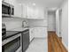 A kitchen is shown with stainless steel appliances and white cabinets and hardwood floors at 320 Lakeview St # 222, Orlando, FL 32804