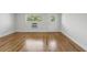 Bright living room featuring wood floors, white walls, a window, and a white door at 320 Lakeview St # 222, Orlando, FL 32804