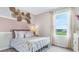 Bright bedroom with decorative wall accents, a comfy bed, and scenic outdoor views through the window at 3206 Partington Blvd, Davenport, FL 33837