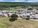An aerial view shows a vibrant community with manicured lawns near a golf course, lake and mature trees at 367 Par Pines Blvd, Davenport, FL 33837