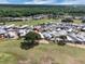 An aerial view shows a vibrant community with manicured lawns near a golf course, lake and mature trees at 367 Par Pines Blvd, Davenport, FL 33837