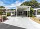 White home featuring a covered carport, mature landscaping, and bright blue skies at 367 Par Pines Blvd, Davenport, FL 33837