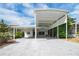 Bright white home featuring a covered carport, mature landscaping, and blue skies at 367 Par Pines Blvd, Davenport, FL 33837