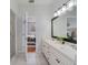 Bright bathroom with double sinks and a glass enclosed shower, with a doorway to the bedroom at 4544 Point Look Out Rd, Orlando, FL 32808