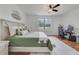 Bright bedroom with a large bed, ceiling fan, wood floors and computer desk by the window at 4544 Point Look Out Rd, Orlando, FL 32808