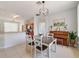 Bright dining room with a wooden table, view to kitchen, piano, and tile floors at 4544 Point Look Out Rd, Orlando, FL 32808