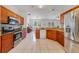 Open kitchen with stainless steel appliances, granite countertops, tile floors, and wooden cabinets at 4544 Point Look Out Rd, Orlando, FL 32808