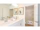 Bathroom with double sinks, white cabinets, framed art and an alcove bathtub with shower at 4718 Yellow Elder Way, Kissimmee, FL 34758