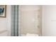 Clean bathroom featuring a tub-shower combo with tiled surround and a patterned shower curtain at 4718 Yellow Elder Way, Kissimmee, FL 34758