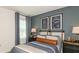Nicely decorated bedroom with striking dark wall, complemented by football themed artwork and stylish bedding at 4718 Yellow Elder Way, Kissimmee, FL 34758