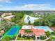 Picturesque view showcasing community amenities: a tennis court, pool, and clubhouse near a serene lake at 5160 Conroy Rd # 1423, Orlando, FL 32811