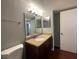Bathroom featuring a granite vanity top, decorative mirror and lighting fixtures at 5160 Conroy Rd # 1423, Orlando, FL 32811