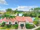 Charming clubhouse exterior with decorative trim, palm trees, and manicured landscaping in a gated community at 5160 Conroy Rd # 1423, Orlando, FL 32811
