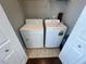 Laundry room featuring a washer and dryer with shelving, and tiled flooring at 5160 Conroy Rd # 1423, Orlando, FL 32811