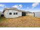 Spacious backyard with a covered patio, lush lawn, and a modern home exterior at 5511 Orange Orchard Dr, Winter Garden, FL 34787