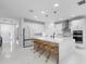 Bright kitchen featuring a spacious island with bar stools, modern appliances, and white cabinetry at 5511 Orange Orchard Dr, Winter Garden, FL 34787