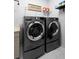 Convenient laundry room with side-by-side washer and dryer, shelving, and ample countertop space at 5511 Orange Orchard Dr, Winter Garden, FL 34787