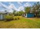 View of the house exterior surrounded by a grassy yard and sunny sky at 55119 5Th St, Astor, FL 32102