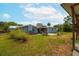 Exterior view of the home with a grassy backyard and a small patio area at 55119 5Th St, Astor, FL 32102