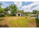 Spacious backyard featuring a detached shed with a concrete slab and lush lawn at 55119 5Th St, Astor, FL 32102