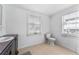 Bright bathroom featuring a dark vanity with granite counters, a toilet and tiled floors at 55119 5Th St, Astor, FL 32102
