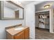 Bathroom with a wooden vanity, a mirror and a walk-in closet at 55119 5Th St, Astor, FL 32102