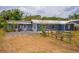 Exterior shot of the house with a gravel driveway and an adjacent fenced yard at 55119 5Th St, Astor, FL 32102