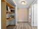 Hallway with built in wood shelving and wood-look floors leading to a sunny living space at 55119 5Th St, Astor, FL 32102