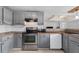 Updated kitchen showcases grey cabinets, stainless steel appliances, and efficient layout, optimizing space and functionality at 55119 5Th St, Astor, FL 32102