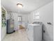 Bright laundry room featuring a washing machine, water heater, and storage shelves at 55119 5Th St, Astor, FL 32102