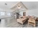 Spacious living room with wood-look floors, sofas, and a view of the kitchen area at 55119 5Th St, Astor, FL 32102