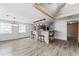 Open-concept living room with wood-look floors, kitchen bar, and large windows for natural light at 55119 5Th St, Astor, FL 32102