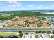 High-angle view of a condo complex showcasing landscaping, red tile roofs, and a roadway nearby at 5530 Metrowest Blvd # 309, Orlando, FL 32811