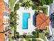 Overhead view of a pool surrounded by lounge chairs, landscaping, and a building with a red roof at 5530 Metrowest Blvd # 309, Orlando, FL 32811