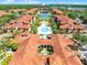 Aerial view of a community featuring a pool, courtyard, and various buildings with red tile roofs at 5530 Metrowest Blvd # 309, Orlando, FL 32811