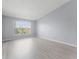 Bright bedroom with neutral walls, modern flooring, and a large window offering natural light and neighborhood views at 5530 Metrowest Blvd # 309, Orlando, FL 32811