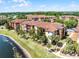 Apartment building exterior view showcasing multiple units with private balconies overlooking a pond and grassy area at 5530 Metrowest Blvd # 309, Orlando, FL 32811