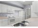 Functional kitchen with white appliances and cabinetry; the perfect layout for a clean, modern living space at 5530 Metrowest Blvd # 309, Orlando, FL 32811