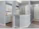 Cozy kitchen featuring white cabinets and a breakfast bar open to the living space with neutral walls at 5530 Metrowest Blvd # 309, Orlando, FL 32811