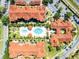 Stunning aerial view of community pool, landscaping, parking, and red tiled roofs at 5566 Metrowest Blvd # 304, Orlando, FL 32811