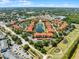 Beautiful aerial view of a community featuring a central pond, lush landscaping, and well-maintained red-tiled roof buildings at 5566 Metrowest Blvd # 304, Orlando, FL 32811