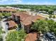 Exterior shot showing multiple stories, the tile roof, and some surrounding trees at 5566 Metrowest Blvd # 304, Orlando, FL 32811