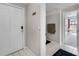 View of the foyer with a white door, tile floor, coat rack and view into the bedroom at 5566 Metrowest Blvd # 304, Orlando, FL 32811