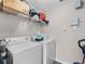 Bright laundry room featuring a washer, dryer, and shelving for storage at 5566 Metrowest Blvd # 304, Orlando, FL 32811