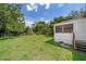 Spacious backyard with green grass, mature trees, screened porch and chain link fence at 5601 Andora St, Orlando, FL 32807