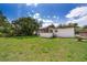 Spacious backyard with green grass, mature trees, screened porch and chain link fence at 5601 Andora St, Orlando, FL 32807